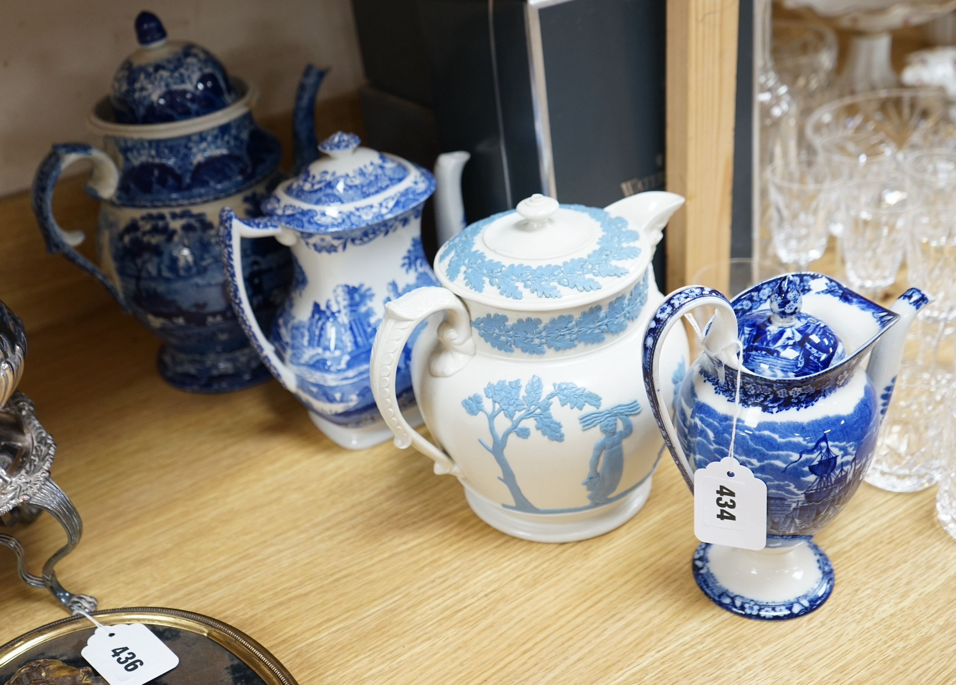 An early 19th century pearlware blue and white tea pot, two others and a Wedgwood style teapot, tallest 30cms high